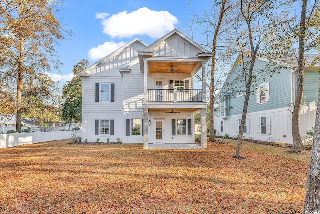 view of front of house with ceiling fan, a balcony, french doors, and a front yard