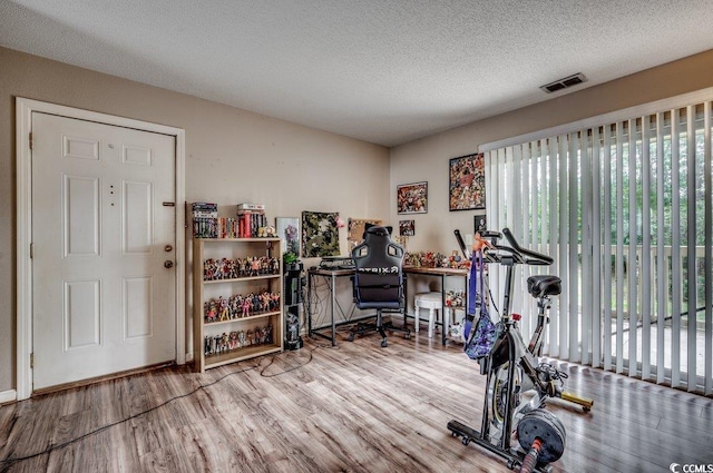 workout area with hardwood / wood-style flooring and a textured ceiling