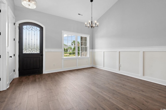309 Waterfall Cir, Little River, SC 29566 - entryway featuring a chandelier, wainscoting, dark wood-type flooring, a decorative wall, and high vaulted ceiling