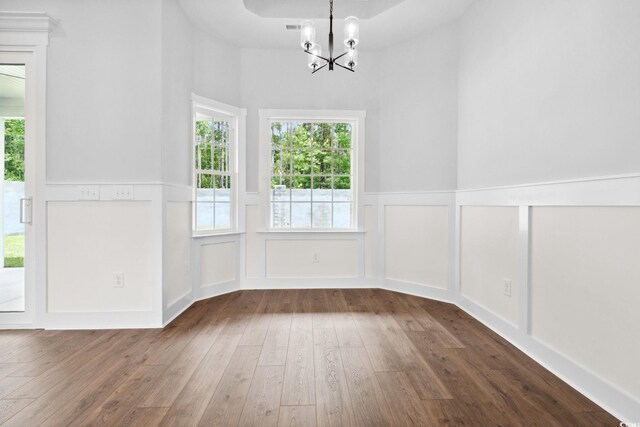 309 Waterfall Cir, Little River, SC 29566 - unfurnished dining area with a chandelier, hardwood / wood-style floors, a wainscoted wall, a decorative wall, and plenty of natural light