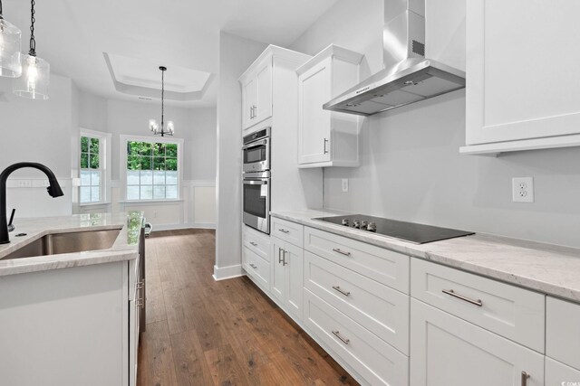309 Waterfall Cir, Little River, SC 29566 - kitchen with wall chimney range hood, a sink, black electric stovetop, dark wood-style flooring, and stainless steel double oven