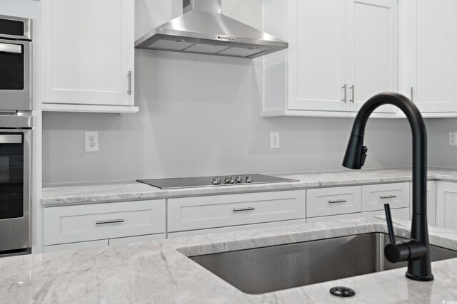 297 Waterfall Cir, Little River, SC 29566 - kitchen featuring wall chimney exhaust hood, white cabinetry, oven, and black electric cooktop