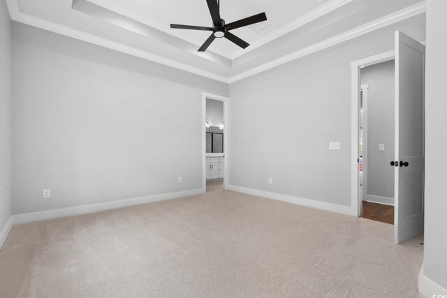 297 Waterfall Cir, Little River, SC 29566 - unfurnished bedroom with a tray ceiling, carpet, ornamental molding, ensuite bathroom, and baseboards