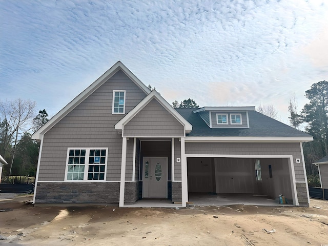 craftsman-style home featuring a garage and stone siding