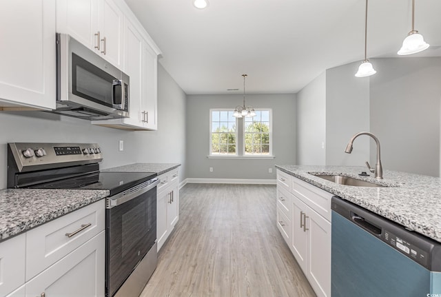 650 Timber Creek Dr, Loris, SC 29569 - kitchen with stainless steel appliances, a sink, light wood-style floors, white cabinetry, and a chandelier