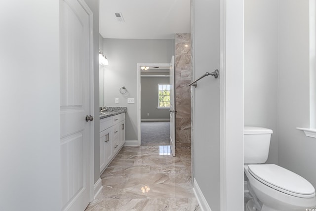 bathroom featuring toilet, visible vents, vanity, baseboards, and marble finish floor