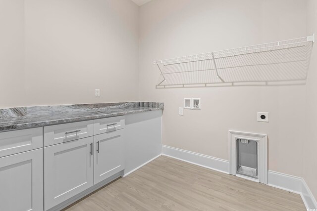 293 Waterfall Cir, Little River, SC 29566 - kitchen with wall chimney range hood, stainless steel double oven, black electric cooktop, white cabinets, and light stone counters