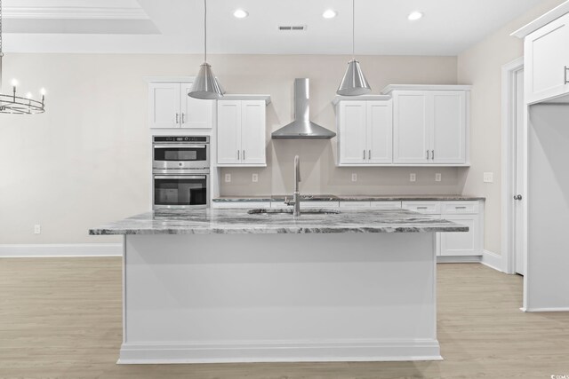 293 Waterfall Cir, Little River, SC 29566 - kitchen with wall chimney exhaust hood, stainless steel double oven, light wood finished floors, white cabinetry, and recessed lighting