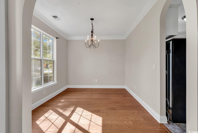 spare room featuring ornamental molding, a chandelier, and light hardwood / wood-style floors