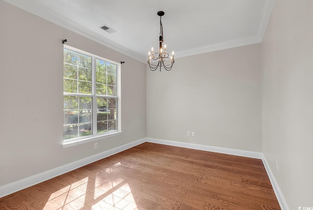 empty room with an inviting chandelier, ornamental molding, and hardwood / wood-style flooring