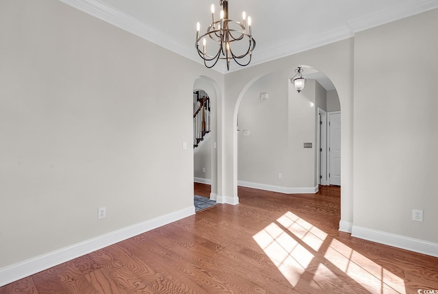 unfurnished dining area with wood-type flooring, crown molding, and a chandelier