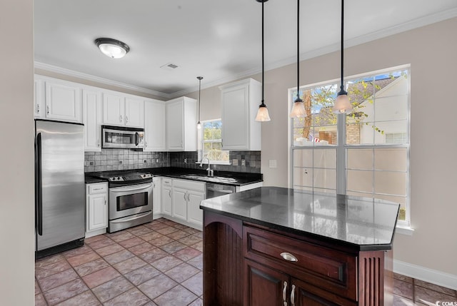 kitchen featuring appliances with stainless steel finishes, pendant lighting, and white cabinets