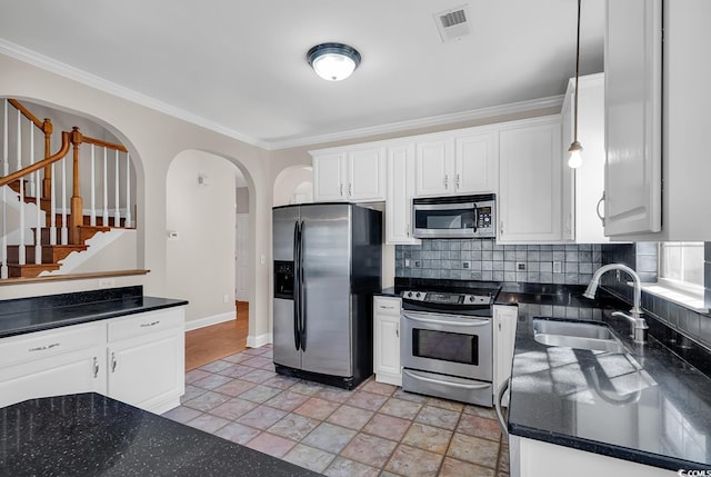 kitchen featuring hanging light fixtures, white cabinets, appliances with stainless steel finishes, and sink