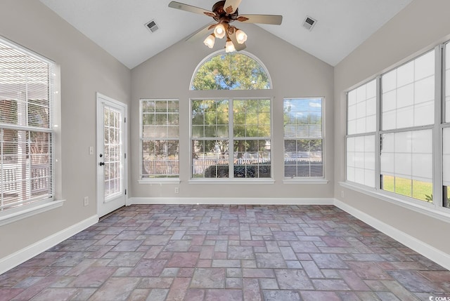 unfurnished sunroom featuring ceiling fan, vaulted ceiling, and a wealth of natural light