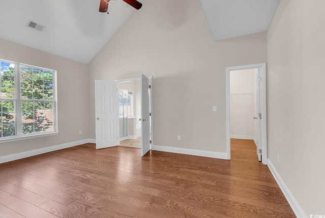 spare room featuring hardwood / wood-style flooring, high vaulted ceiling, and ceiling fan