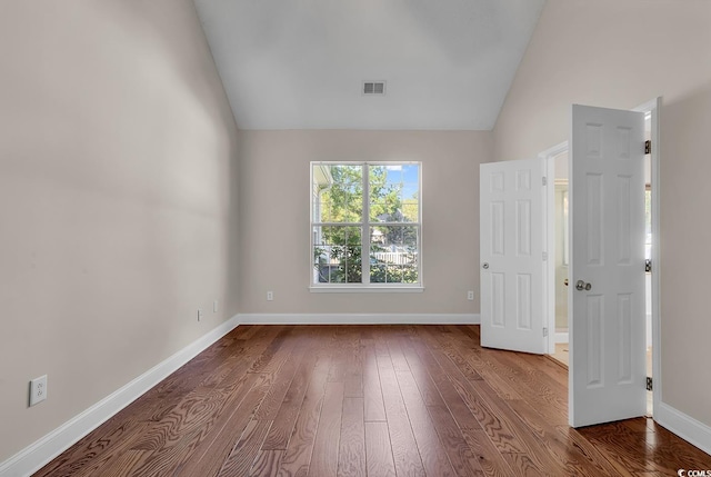 unfurnished room with lofted ceiling and wood-type flooring