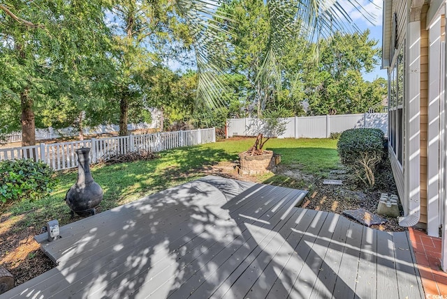 wooden deck featuring a lawn