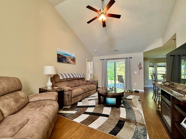 living room featuring ceiling fan, high vaulted ceiling, and dark hardwood / wood-style flooring