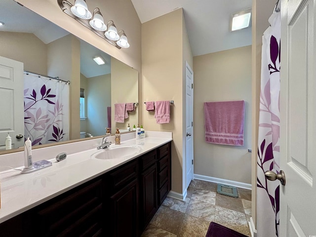 bathroom with vanity and lofted ceiling