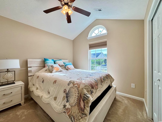 bedroom featuring a closet, dark carpet, vaulted ceiling, and ceiling fan