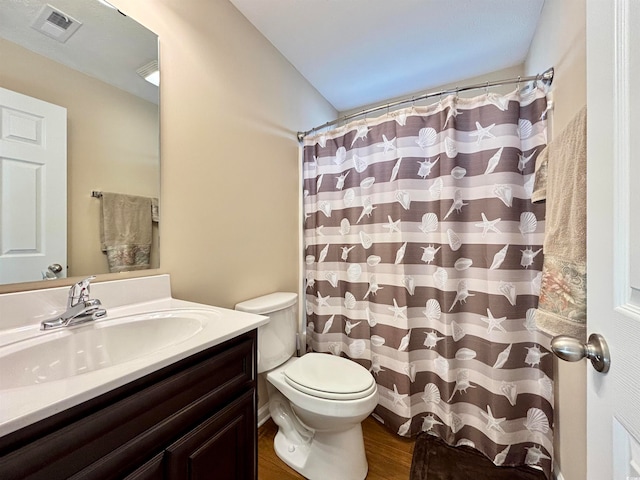 bathroom with vanity, wood-type flooring, toilet, and walk in shower