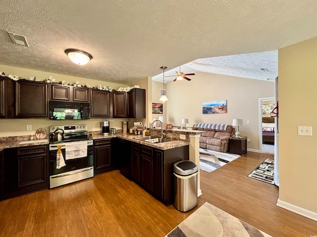 kitchen featuring black appliances, sink, kitchen peninsula, light hardwood / wood-style floors, and pendant lighting