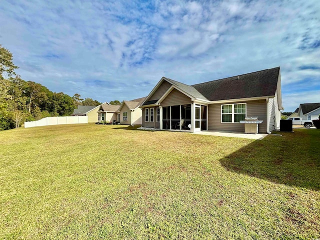 back of house featuring a yard and a sunroom