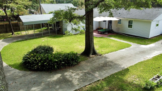 view of yard with a carport and fence