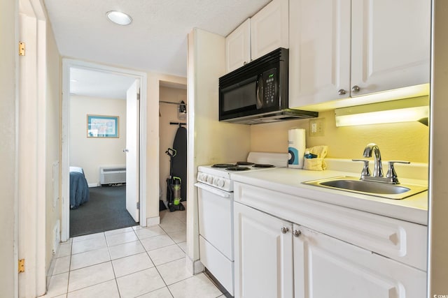 kitchen with white cabinets, light tile patterned flooring, white range with gas stovetop, and sink