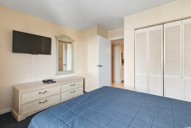 unfurnished bedroom with a closet, dark tile patterned flooring, and a textured ceiling