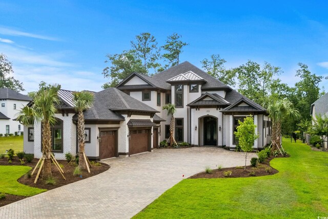 372 Chamberlin Rd, Myrtle Beach, SC 29588 - view of front of property with decorative driveway, a front yard, stucco siding, and a standing seam roof