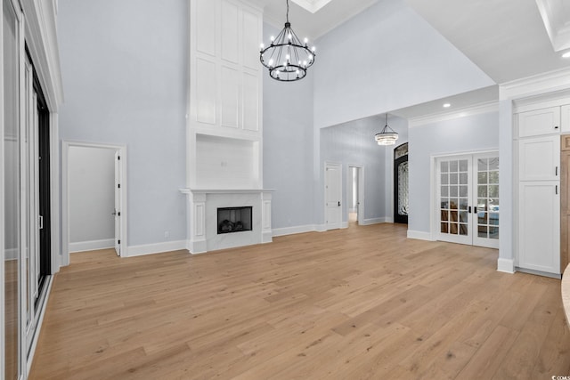 372 Chamberlin Rd, Myrtle Beach, SC 29588 - unfurnished living room featuring a high ceiling, light wood-style flooring, a chandelier, a fireplace, and ornamental molding