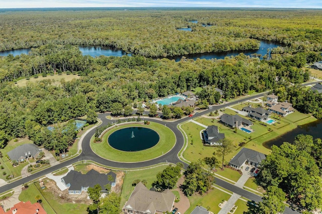 drone / aerial view with a water view, a residential view, and a view of trees