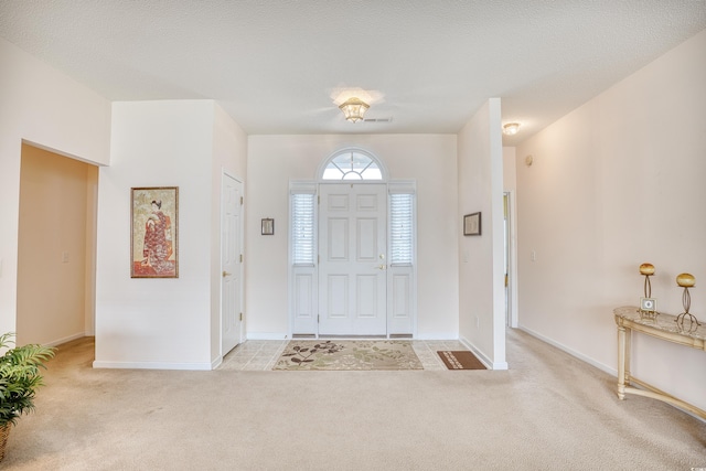 carpeted foyer featuring baseboards