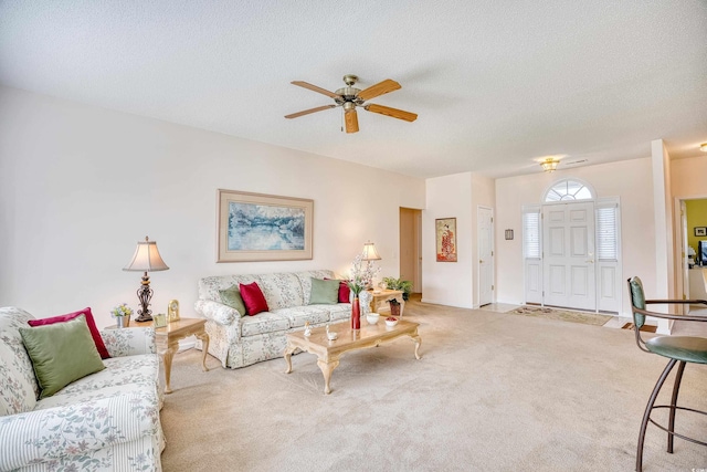 living area featuring a ceiling fan, carpet, and a textured ceiling