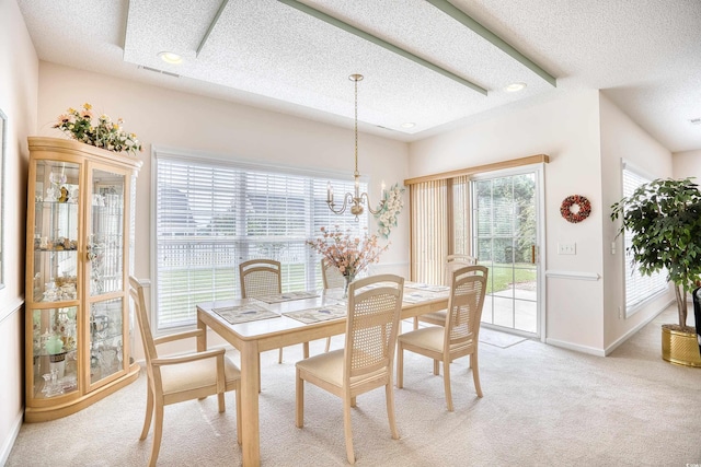 dining area with a textured ceiling, light colored carpet, a chandelier, and baseboards