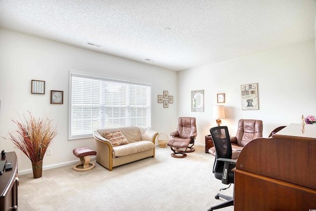 carpeted office featuring a textured ceiling and baseboards