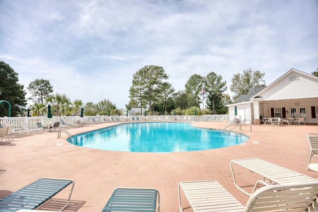 community pool featuring fence and a patio