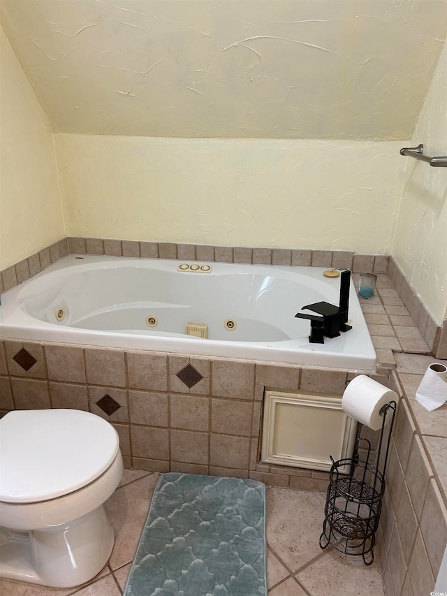 bathroom with tile patterned floors, a relaxing tiled tub, and toilet