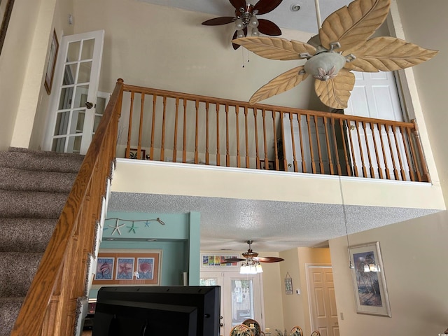 stairway featuring ceiling fan and a textured ceiling