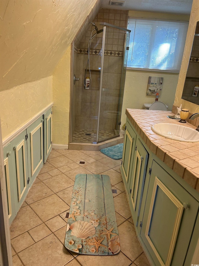 bathroom featuring vanity, a shower with shower door, and tile patterned flooring