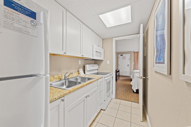 kitchen featuring sink, light tile patterned floors, white cabinets, and white appliances