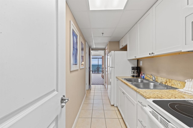 kitchen with sink, a paneled ceiling, white range with electric cooktop, white cabinetry, and light tile patterned flooring