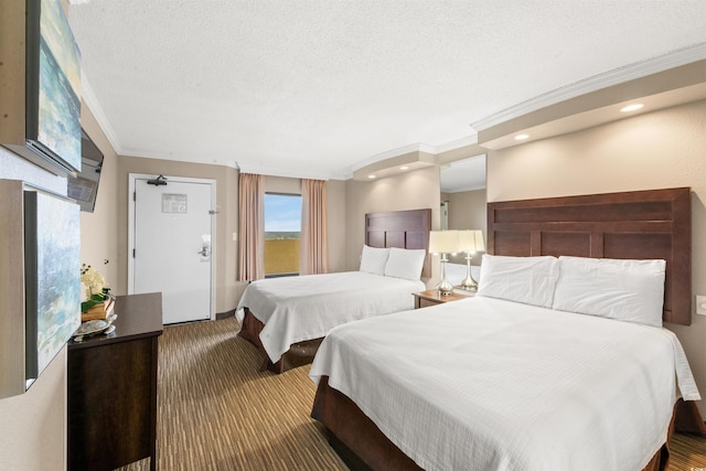 carpeted bedroom with ornamental molding and a textured ceiling