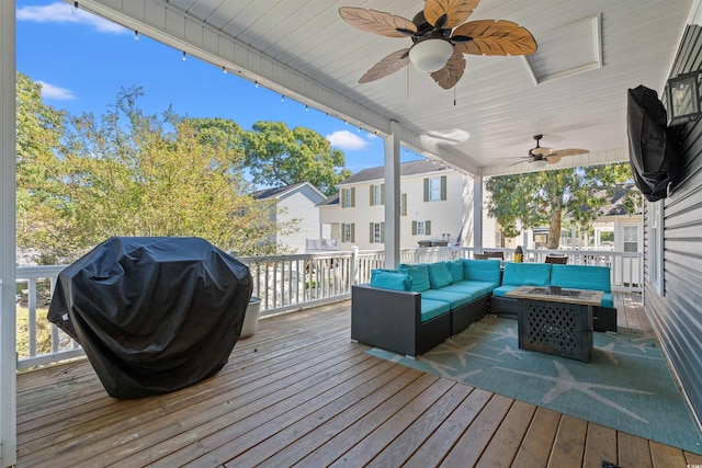 wooden deck with grilling area, an outdoor living space with a fire pit, and ceiling fan