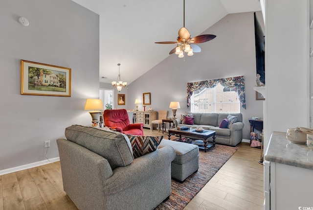 living room featuring ceiling fan with notable chandelier, high vaulted ceiling, and light wood-type flooring