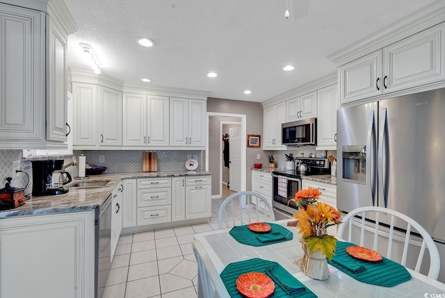 kitchen featuring appliances with stainless steel finishes, decorative backsplash, and white cabinetry