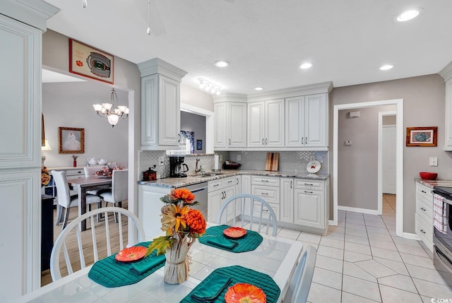 kitchen with appliances with stainless steel finishes, white cabinetry, a chandelier, and backsplash