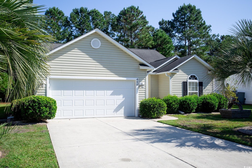 single story home with a front yard and a garage