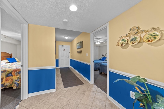 interior space with ceiling fan and a textured ceiling